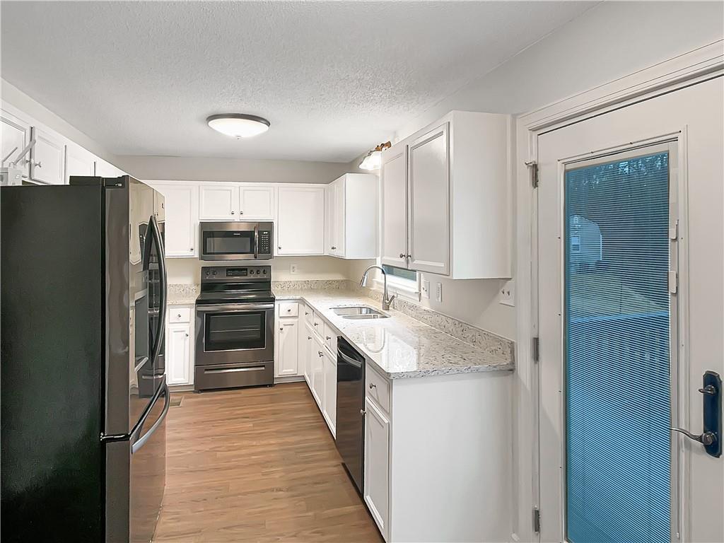 155 Ridgeview Drive Athens, GA 30606 - Photo 7 of 23 a kitchen with a refrigerator sink and cabinets