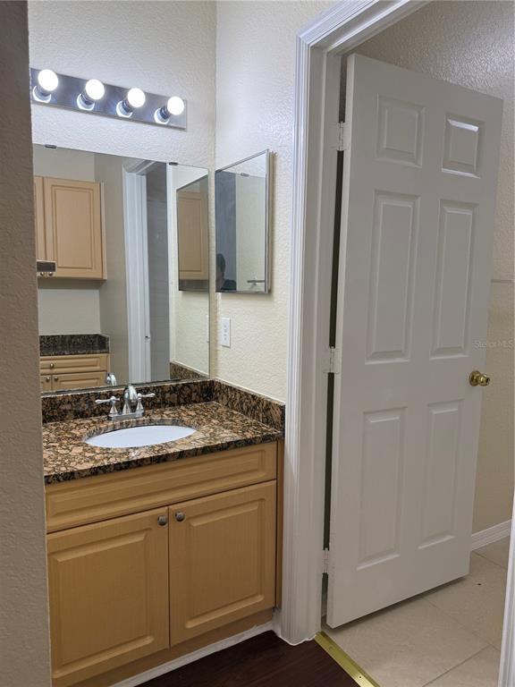 3725 Conroy Road, Unit 2127 Orlando, FL 32839 - Photo 27 of 30 a bathroom with a granite countertop sink and a mirror