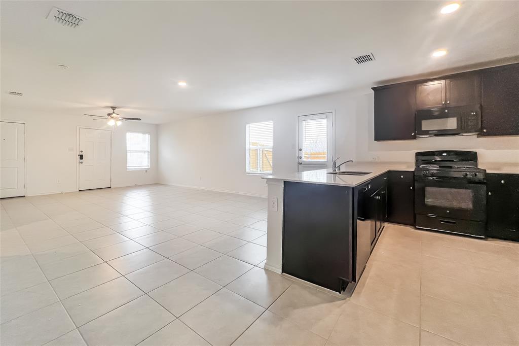 2943 Wallace Wls Court Crandall, TX 75114 - Photo 4 of 16 a kitchen with stainless steel appliances granite countertop a sink and a stove