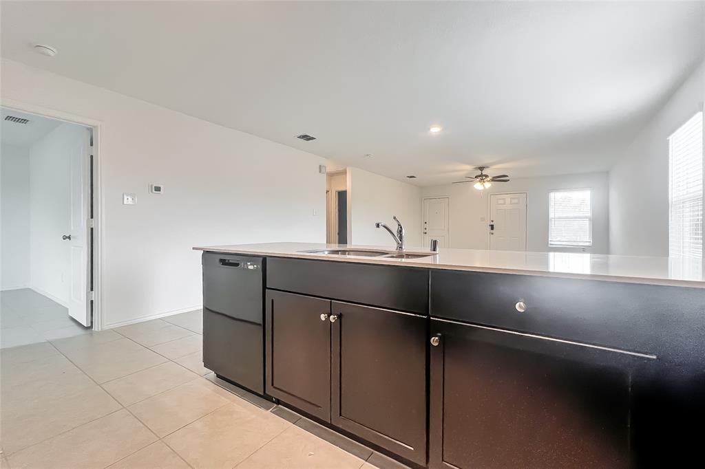 2943 Wallace Wls Court Crandall, TX 75114 - Photo 5 of 16 a kitchen with a refrigerator and white cabinets
