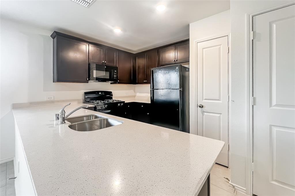 2943 Wallace Wls Court Crandall, TX 75114 - Photo 6 of 16 a kitchen with stainless steel appliances a refrigerator and a sink