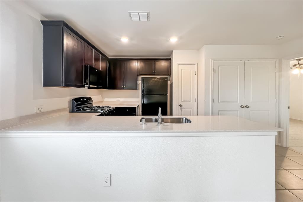 2943 Wallace Wls Court Crandall, TX 75114 - Photo 7 of 16 a view of a kitchen with kitchen island a sink stainless steel appliances and cabinets