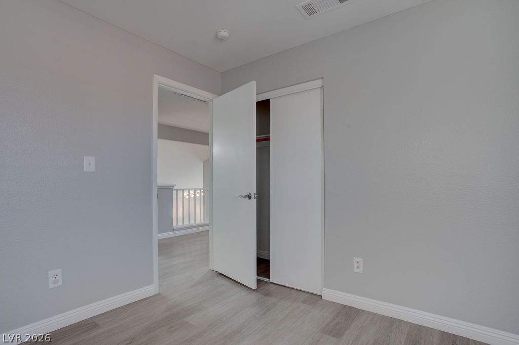 1416 Walstone Road North Las Vegas, NV 89031 - Photo 28 of 47 A quiet bedroom with light-colored flooring and a view to a bright hallway.