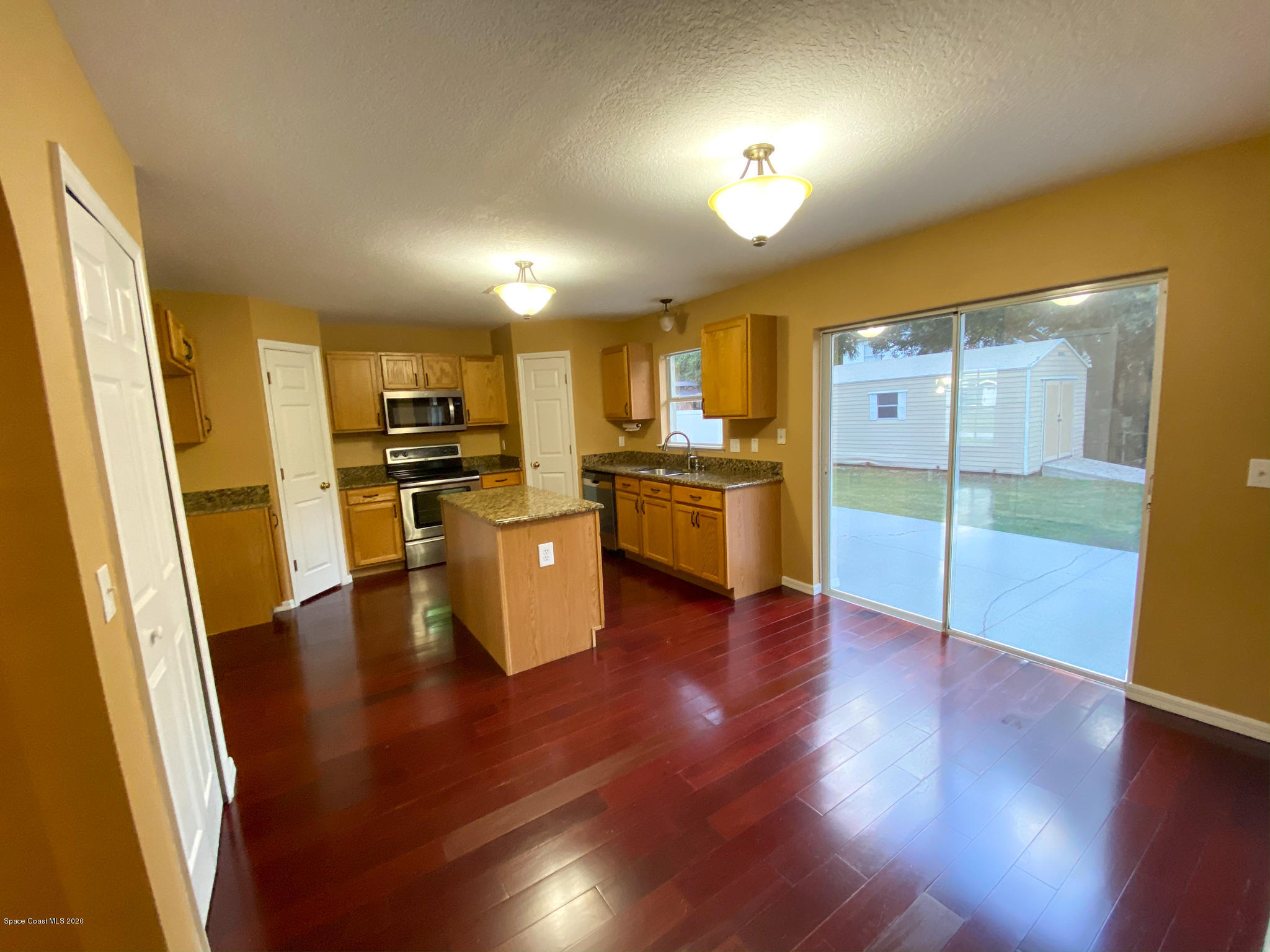 6150 Degan Road Cocoa, FL 32927 - Photo 16 of 48 a kitchen with stainless steel appliances a refrigerator and wooden floor