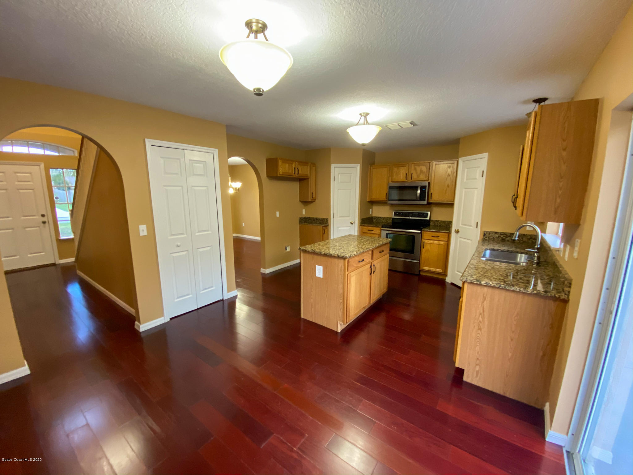 6150 Degan Road Cocoa, FL 32927 - Photo 17 of 48 a open kitchen with cabinets wooden floor and stainless steel appliances