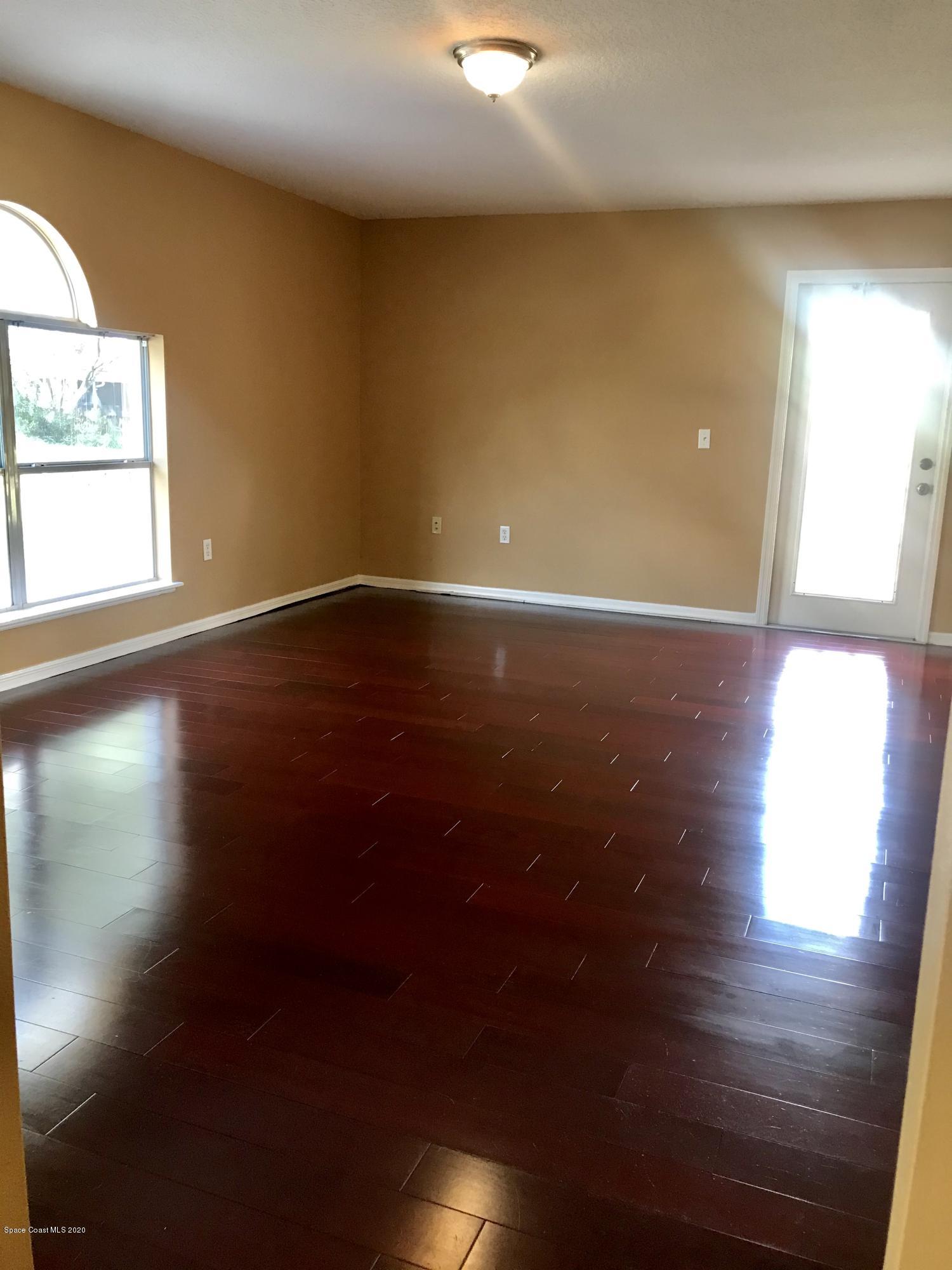 6150 Degan Road Cocoa, FL 32927 - Photo 19 of 48 an empty room with wooden floor and windows
