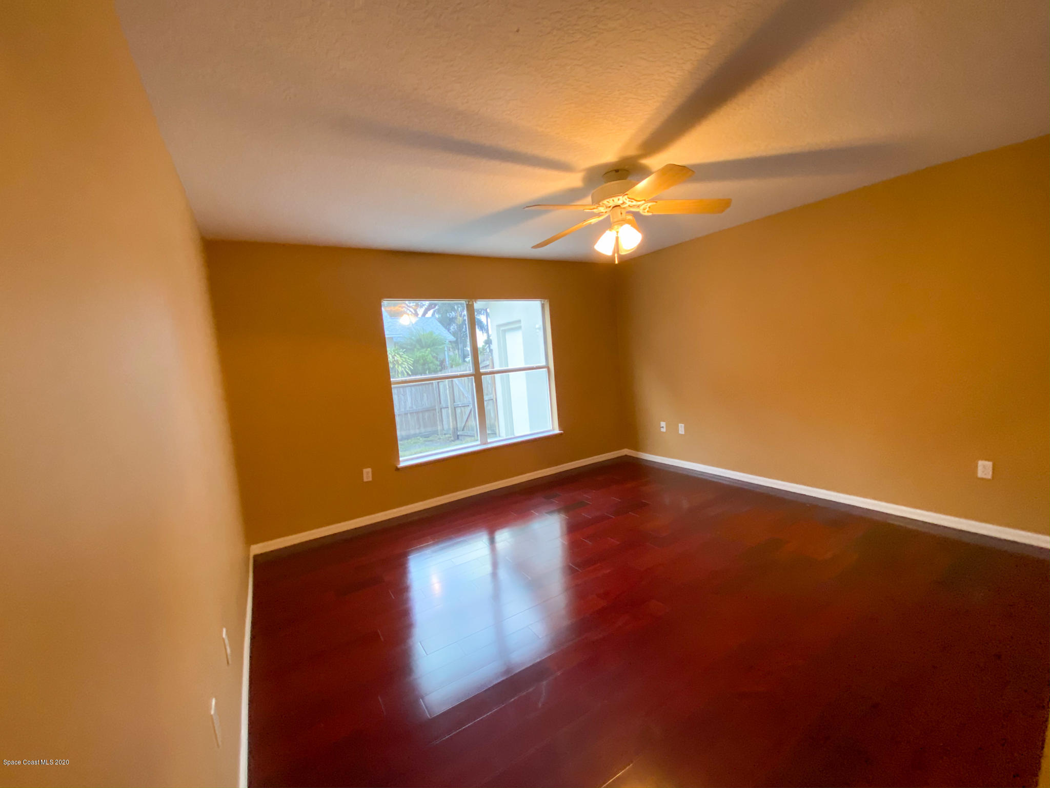 6150 Degan Road Cocoa, FL 32927 - Photo 22 of 48 a view of an empty room with window and wooden floor