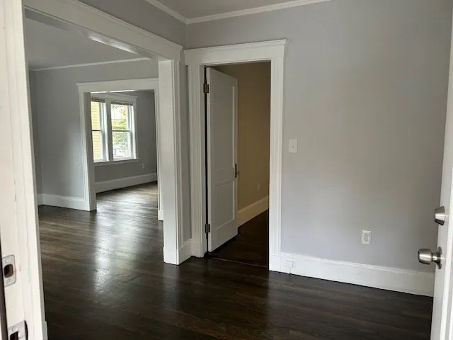 a view of a hallway with hardwood floor and a window