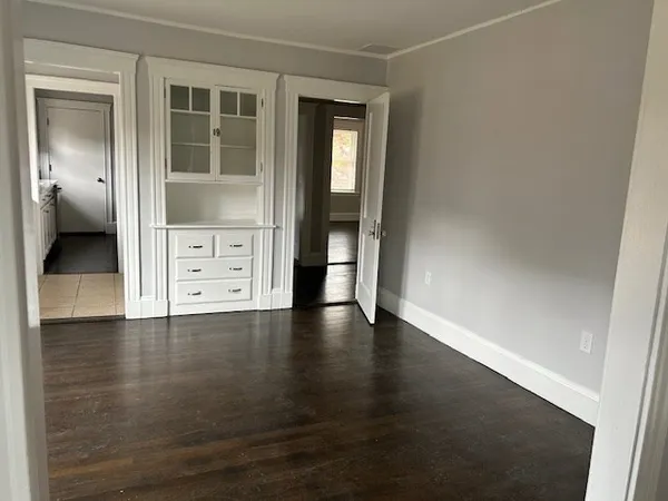 an empty room with mirror and a window