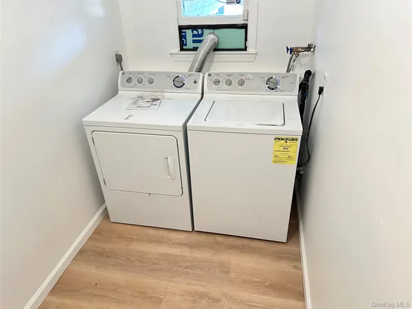 a view of a house with a wooden deck and a barbeque