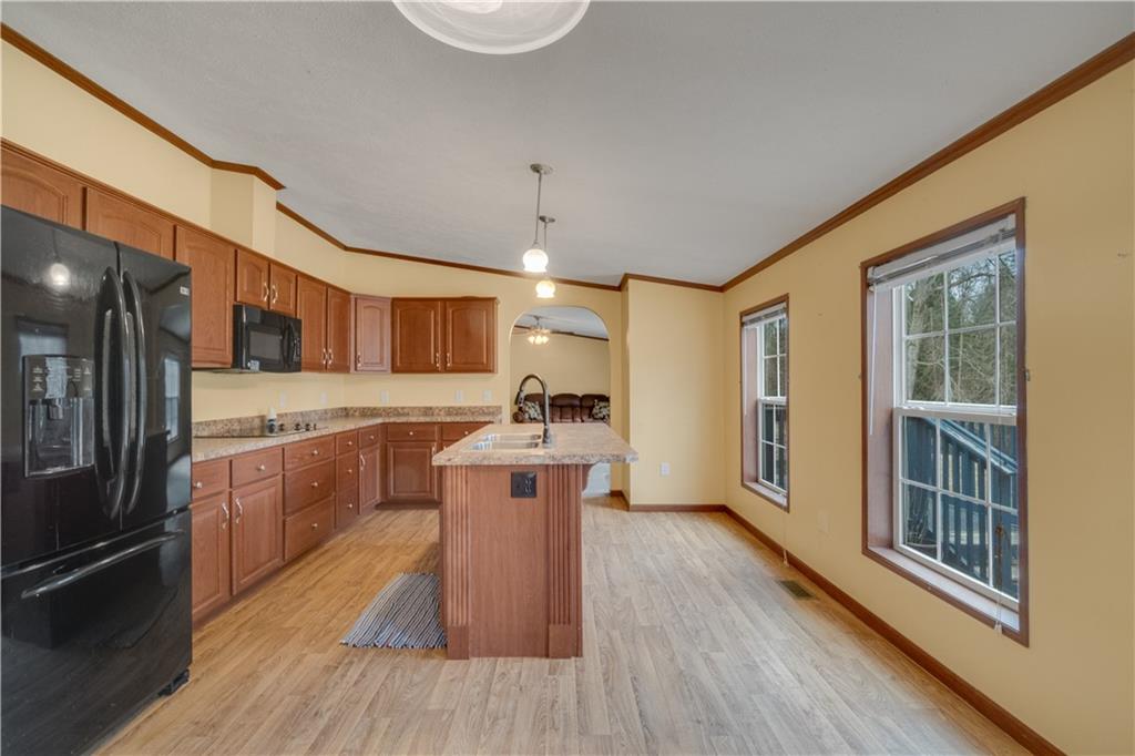 1064 Leesburg Station Road Mercer, PA 16137 - Photo 5 of 25 a kitchen with stainless steel appliances granite countertop a refrigerator a stove a sink dishwasher and wooden cabinets with wooden floor