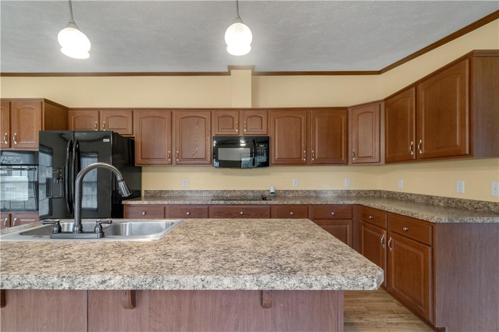 1064 Leesburg Station Road Mercer, PA 16137 - Photo 7 of 25 a kitchen with kitchen island granite countertop a sink a counter space appliances and cabinets