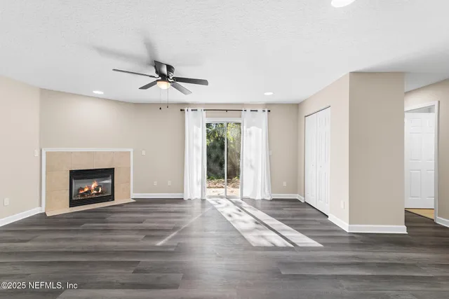 a view of an empty room with a fireplace and a window