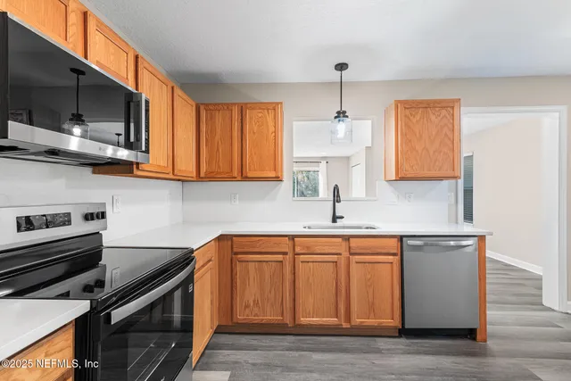 a kitchen with stainless steel appliances a sink stove and microwave