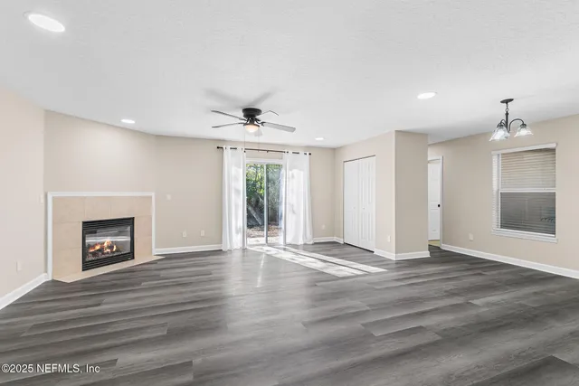 a view of an empty room with a fireplace and a window