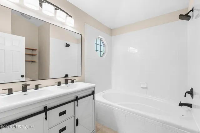 a bathroom with a tub a sink and mirror