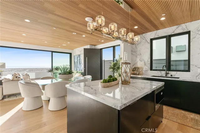 a dining room with granite countertop a table chairs and a potted plant