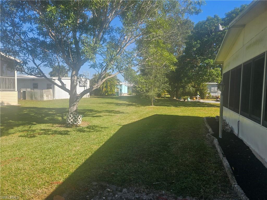 859 Manatee Road Naples, FL 34114 - Photo 31 of 37 View of green lawn featuring a sunroom