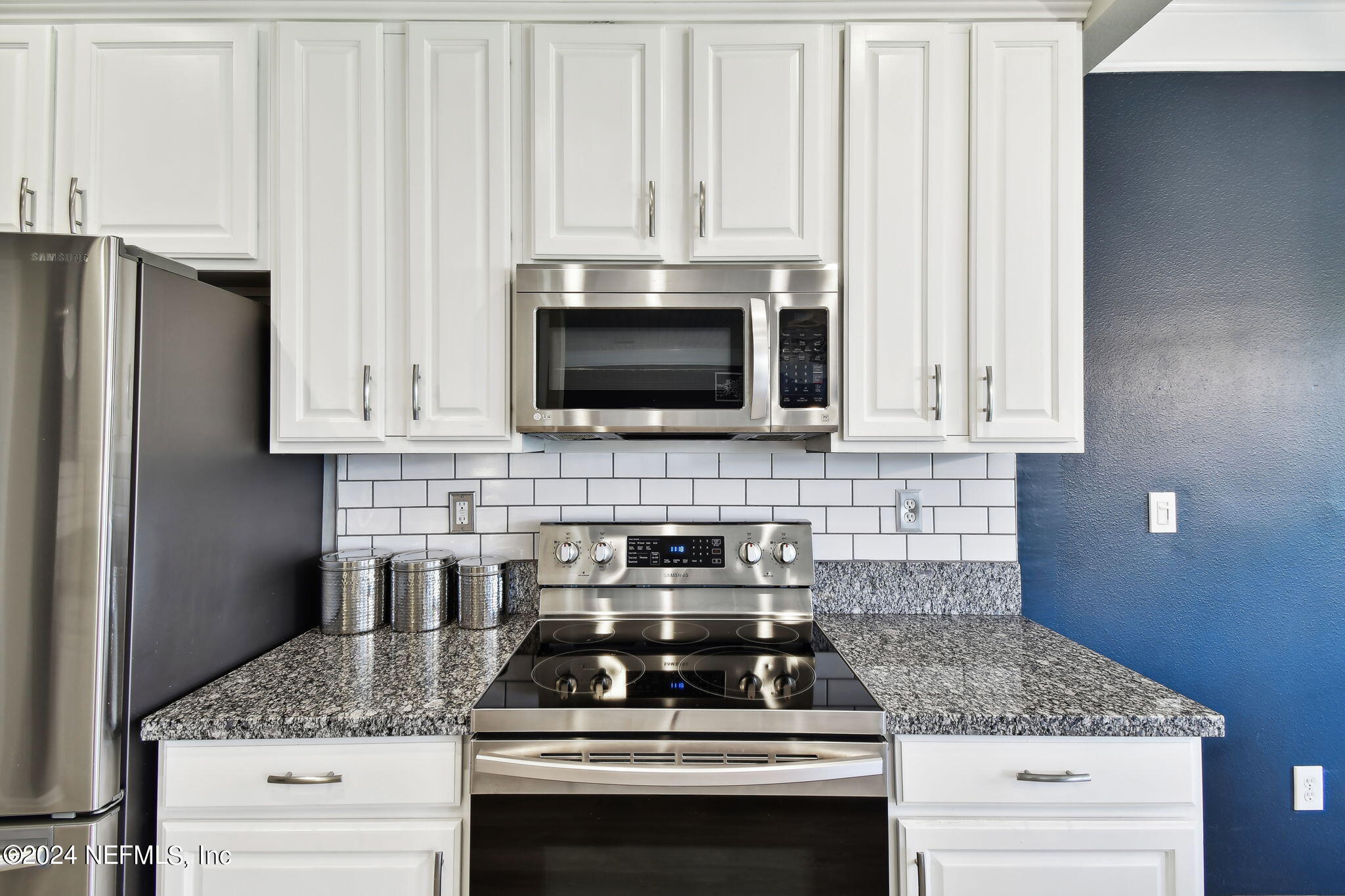 7473 Devondale Way Jacksonville, FL 32256 - Photo 15 of 68 a kitchen with granite countertop white cabinets and stainless steel appliances