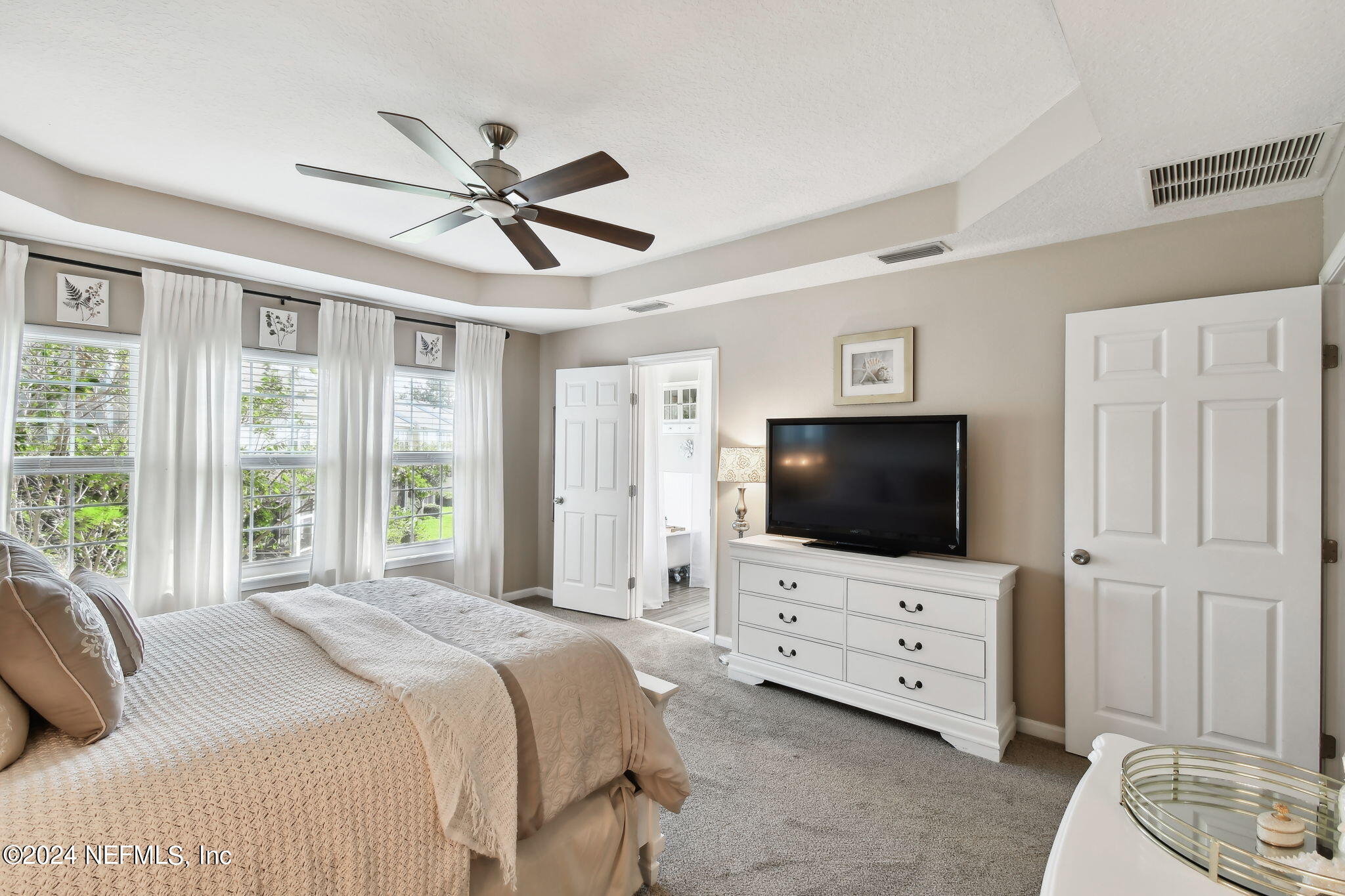 7473 Devondale Way Jacksonville, FL 32256 - Photo 34 of 68 a bedroom with a bed television window and a flat screen television