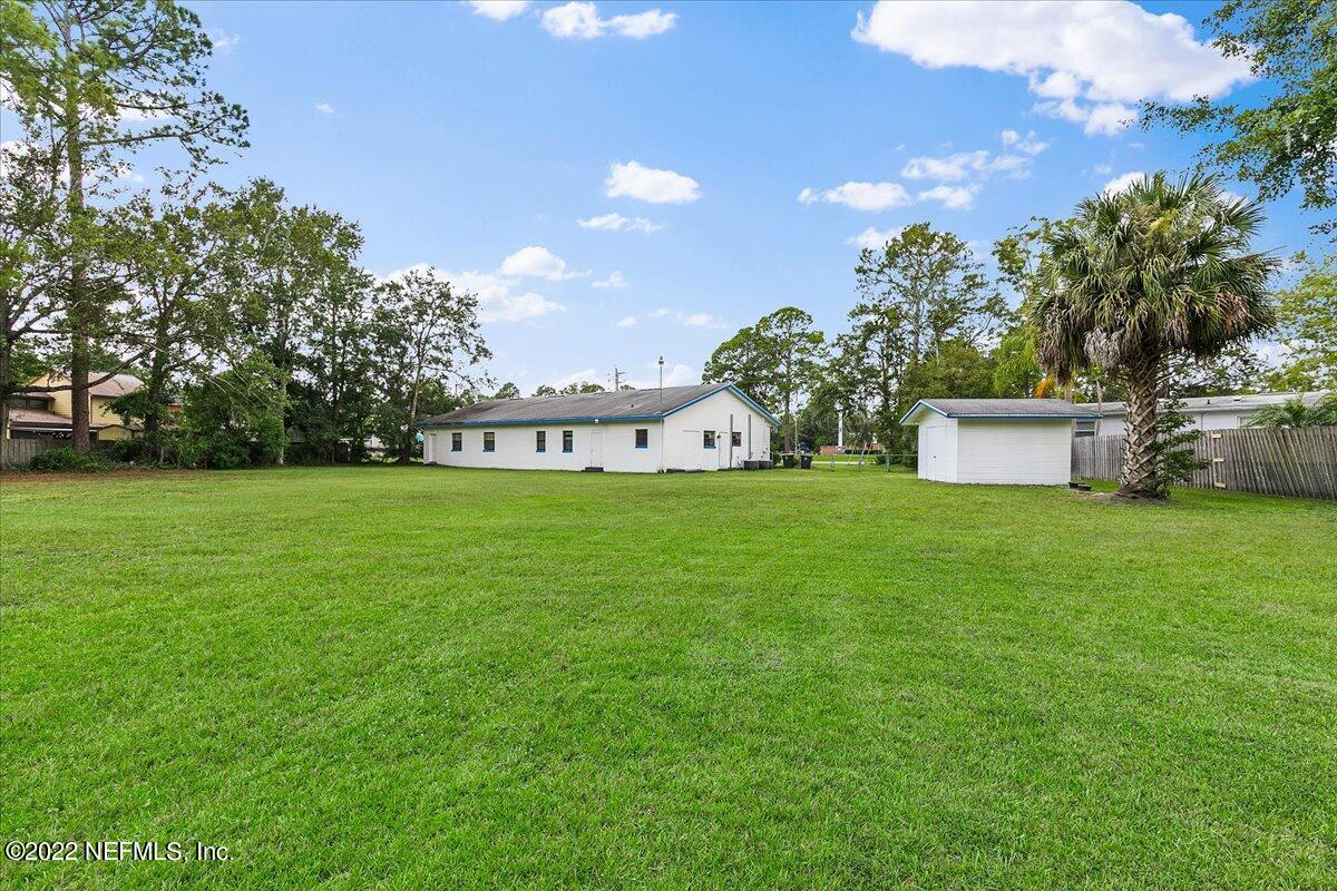 2701 Dean Road Jacksonville, FL 32216 - Photo 18 of 19 a view of a white house with a big yard and large trees