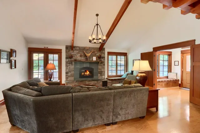 a living room with furniture a fireplace and a floor to ceiling window