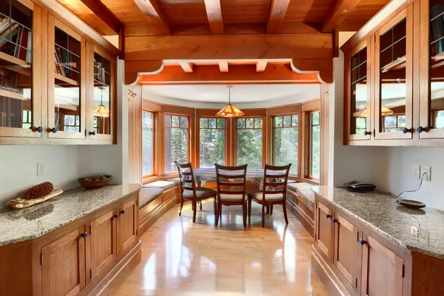 a dining hall with stainless steel appliances granite countertop a stove and cabinets