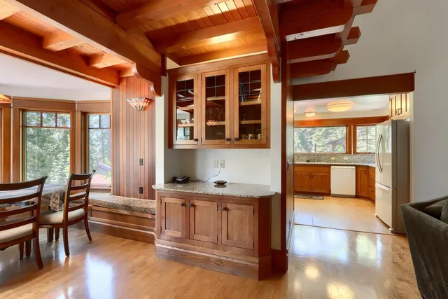 a kitchen with granite countertop a stove and white cabinets next to a large window