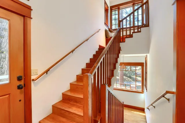 a view of staircase with lots of frames on wall and windows