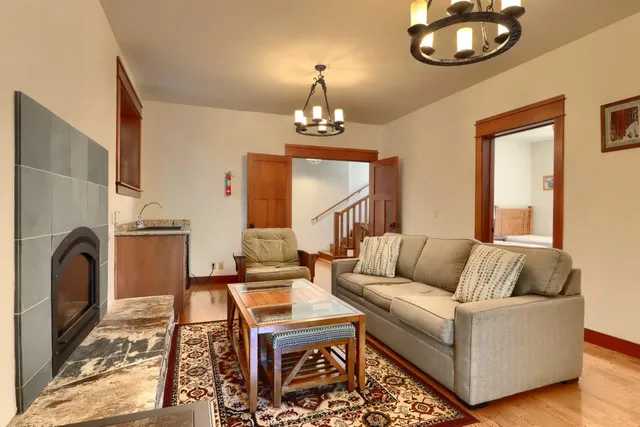 a living room with furniture a mirror and a chandelier