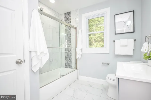 a bathroom with a shower a toilet and a sink