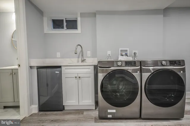 a utility room with sink dryer and washer