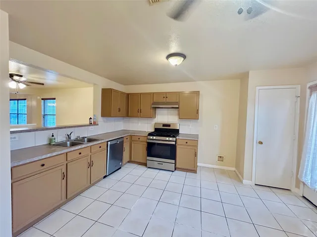 a large kitchen with a stove top oven and sink