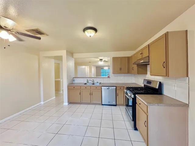 a kitchen with a sink a stove top oven and cabinets