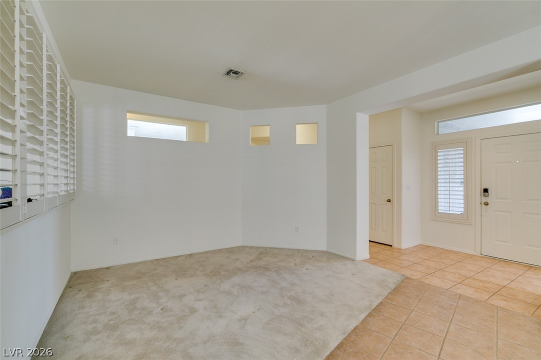 Tiled and carpeted floors define this versatile space adjacent to the main entryway.