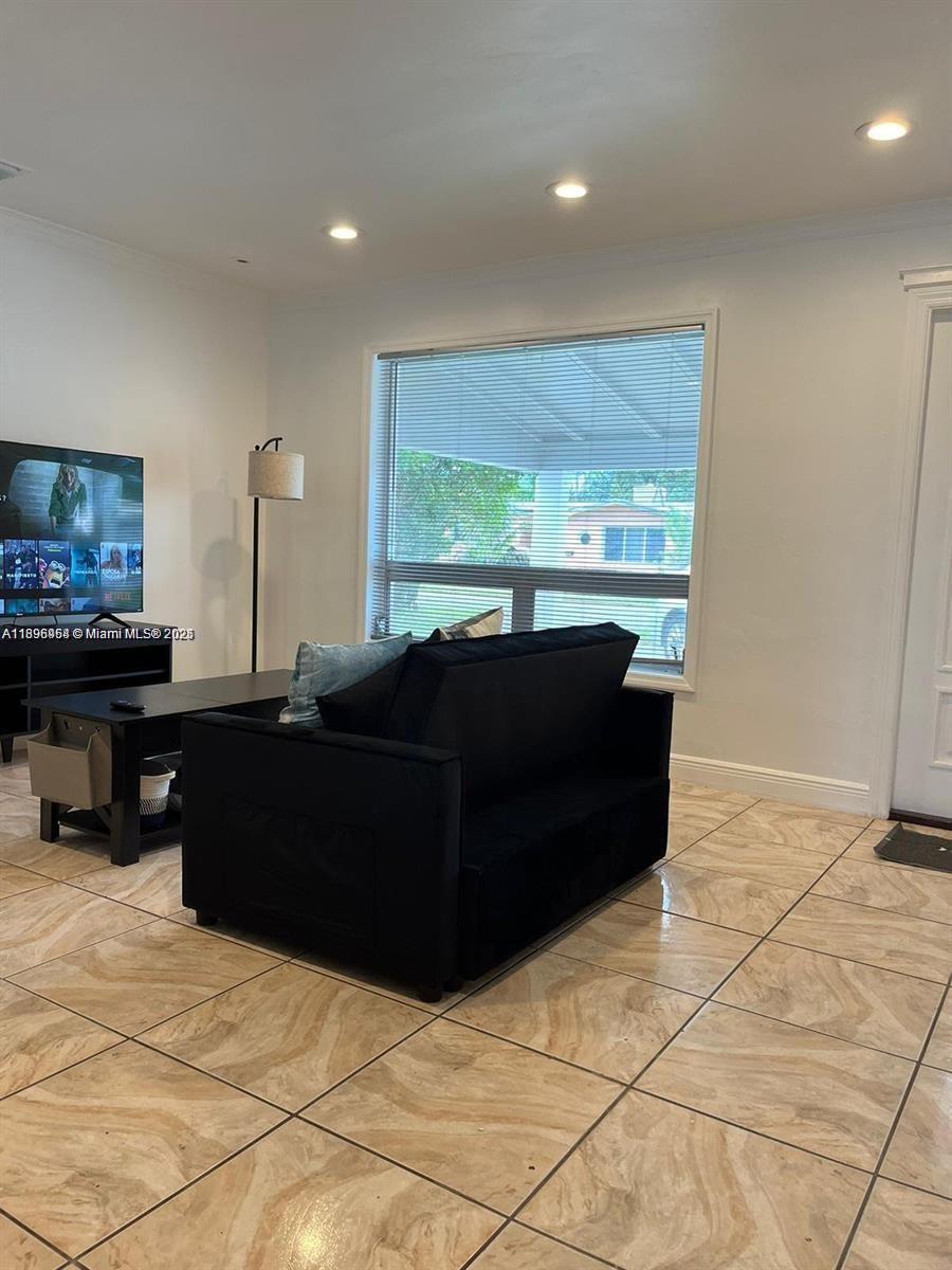 6431 Hayes Street, Unit 2 Hollywood, FL 33024 - Photo 12 of 14 a living room with furniture and a large window