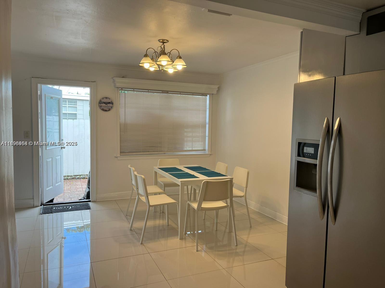 6431 Hayes Street, Unit 2 Hollywood, FL 33024 - Photo 4 of 14 a dining room with furniture and a chandelier