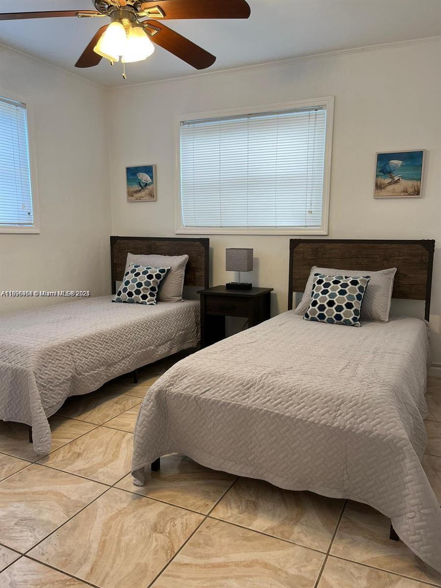 6431 Hayes Street, Unit 2 Hollywood, FL 33024 - Photo 7 of 14 a bedroom with two large bed and a chandelier