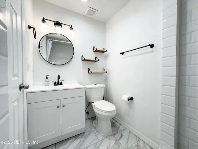 a bathroom with a sink mirror toilet and a shower