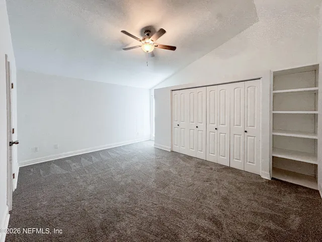 a view of an empty room with a ceiling fan