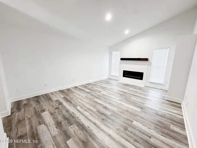 a view of empty room with wooden floor