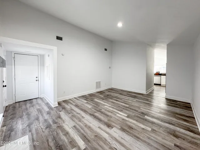a view of empty room with wooden floor