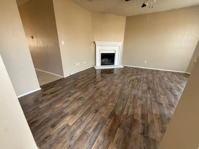 a view of empty room with wooden floor and fireplace