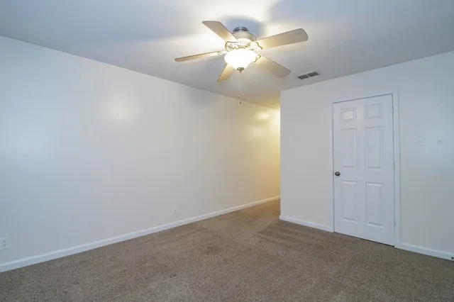 a view of a room with a ceiling fan and a window