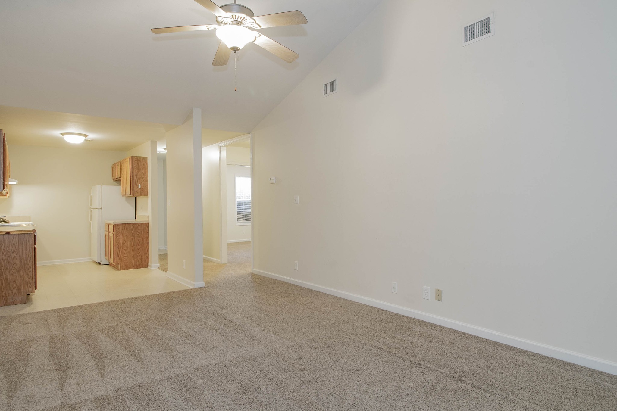299 Raleigh Drive, Unit F2 Clarksville, TN 37043 - Photo 8 of 27 en empty room with a chandelier fan and kitchen view