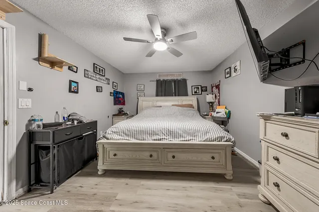 a spacious bedroom with a bed and a chandelier