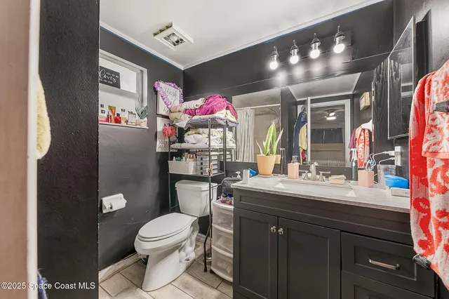 a bathroom with a toilet sink vanity granite and mirror