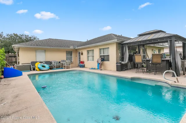 a view of a house with swimming pool and sitting area