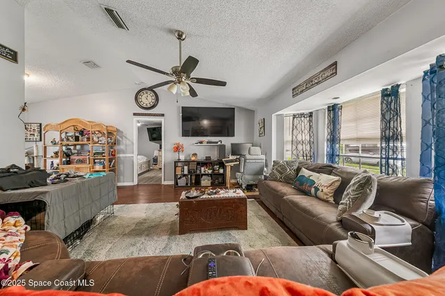 a living room with furniture a large window and a flat screen tv