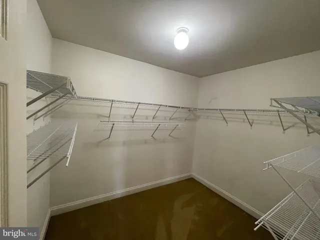 an empty room with a fan & a window